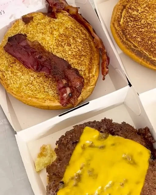 Carne, cheddar e bacon durante la preparazione di un burger Riccio’s